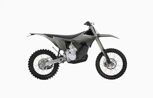 Side view of a gray off-road dirt bike with knobby tires and high front suspension.